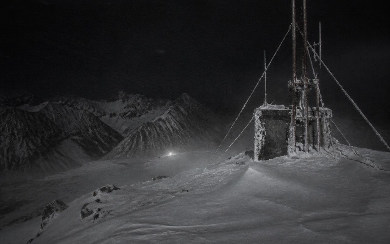 Mountain Station relay mast in deep snow at night